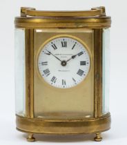 An early 20th century gilt brass carriage clock, of oval form with swing handle on bun feet,