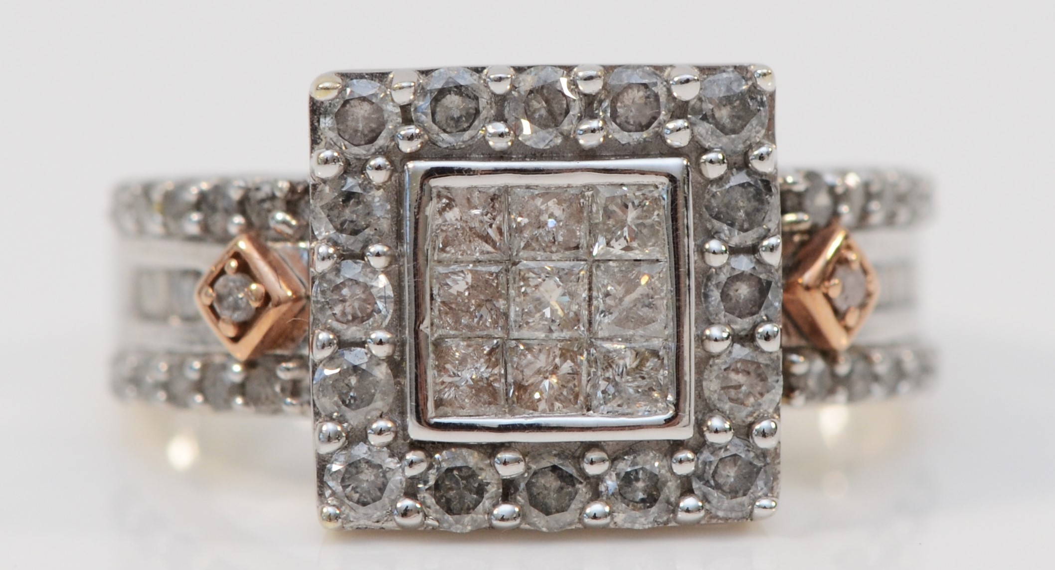 A 9ct white gold and diamond square cluster ring, set with Princess cut stones bordered by