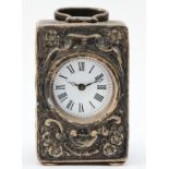 A Victorian silver miniature timepiece, London 1891, with embossed decoration and swing handle,