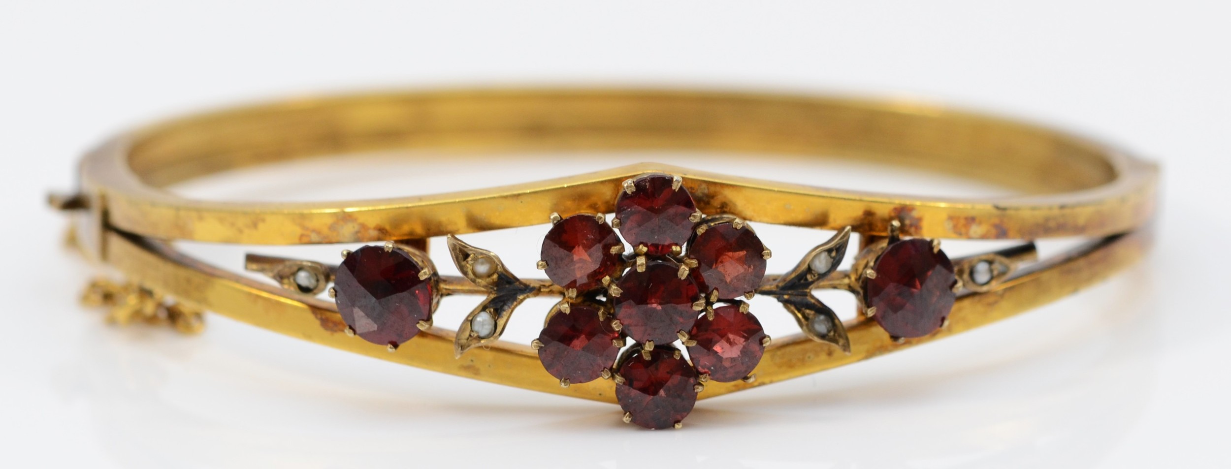 A late 19th century gilt metal and Bohemian garnet cluster bangle, 57 x 47mm.