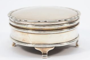 A silver trinket box, Birmingham 1925, with Chippendale border, raised on four scroll feet, diameter