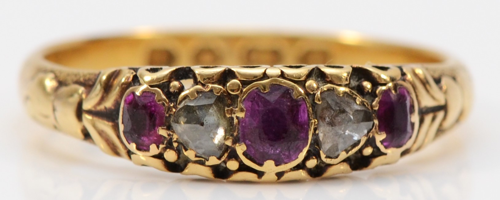 A Victorian 18ct gold, rose diamond and ruby five stone ring, Birmingham 1886, carved shoulders, P