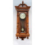 A 20th century mahogany cased Vienna style wall clock, with a stepped pediment and finials, the