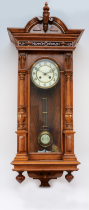 A 20th century mahogany cased Vienna style wall clock, with a stepped pediment and finials, the