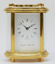 A 20th century English oval brass case carriage clock, the white enamelled dial with Roman numerals,