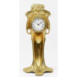 An Art Nouveau gilt brass 8 day mantel clock, in the form of a cloaked female figure holding a