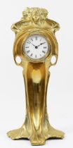 An Art Nouveau gilt brass 8 day mantel clock, in the form of a cloaked female figure holding a