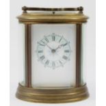An early 20th century brass case carriage clock, of oval form with painted dial and Roman