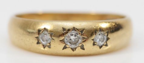 A 9ct gold Edwardian style three stone diamond ring, star gypsy set with brilliant cut stones, O,