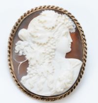 An unmarked 9ct gold mounted oval shell cameo brooch, depicting a Bacchanalian lady, rope twist