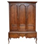 A George III oak livery cupboard, projecting moulded cornice over two panelled doors, the upper