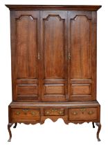 A George III oak livery cupboard, projecting moulded cornice over two panelled doors, the upper