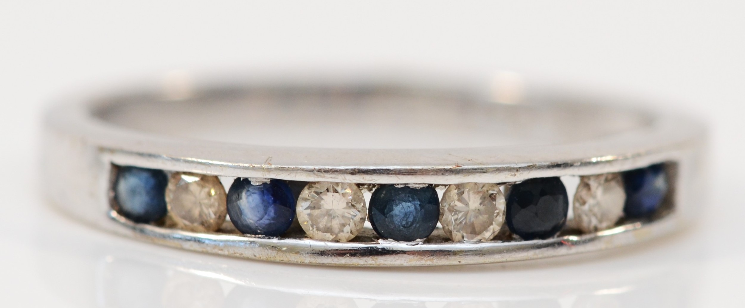 A 9ct white gold sapphire and brilliant cut diamond set half eternity ring, stated weight 0.15cts,