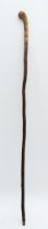 An Oriental walking stick of tapering form, the handle carved with the head of a Chinese Immortal,