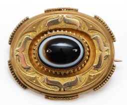 A Victorian unmarked gold oval panel brooch, collet set with a banded agate cabochon, locket back,