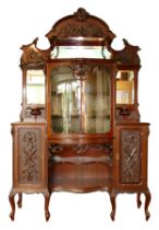 A late Victorian carved mahogany mirror back display cabinet, the carved and pierced decorated