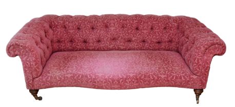 An Edwardian Chesterfield sofa, upholstered in a burgundy Fleur De Lis pattern fabric, buttoned-down