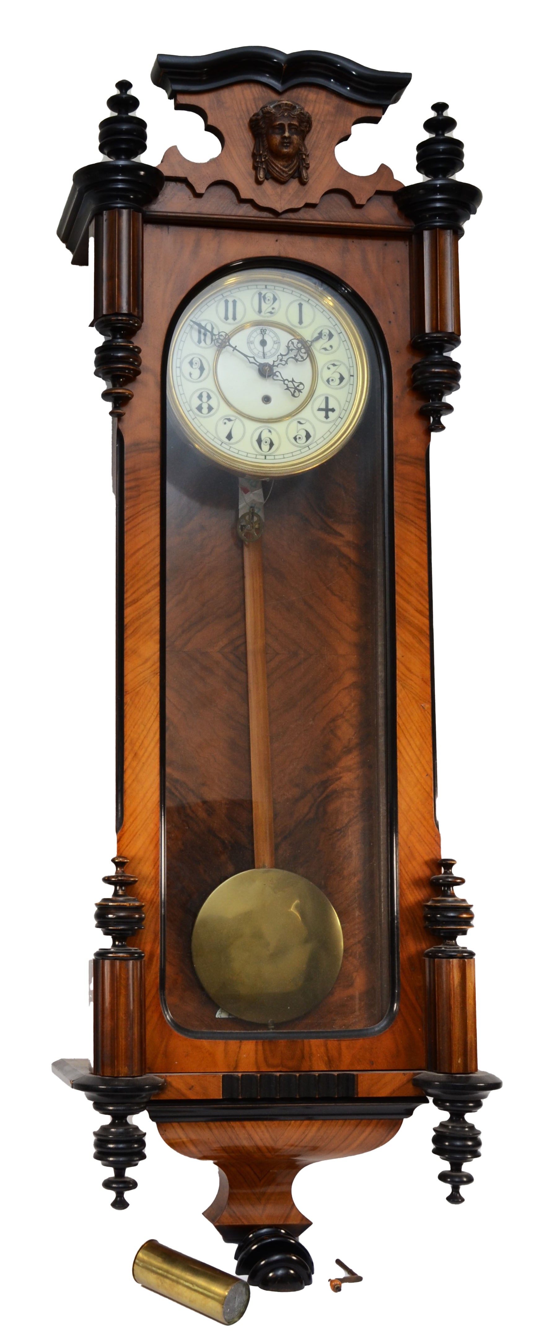 A late 19th century walnut and ebonised Vienna style wall clock, with carved pediment and finials,