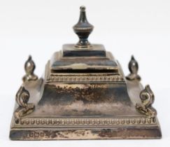 An Edwardian silver inkwell, Sheffield 1910, of square form, with bead border and scroll corners,