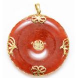 A Chinese 14K gold mounted reddish/brown jadeite disc pendant, diameter 36mm