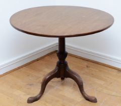 A Georgian mahogany tilt top breakfast table, circular tilt-top on turned and reed carved vasiform