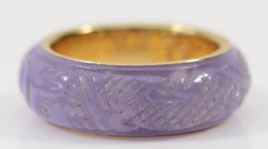 A Chinese 14ct gold and enhanced carved lavender jadeite band ring, depicting two dragons chasing