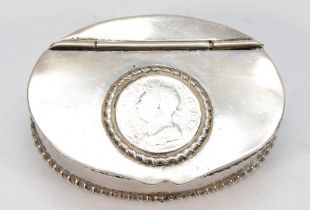 An unmarked white metal oval snuff box, the hinged lid inset with a George IV coin, gadrooned