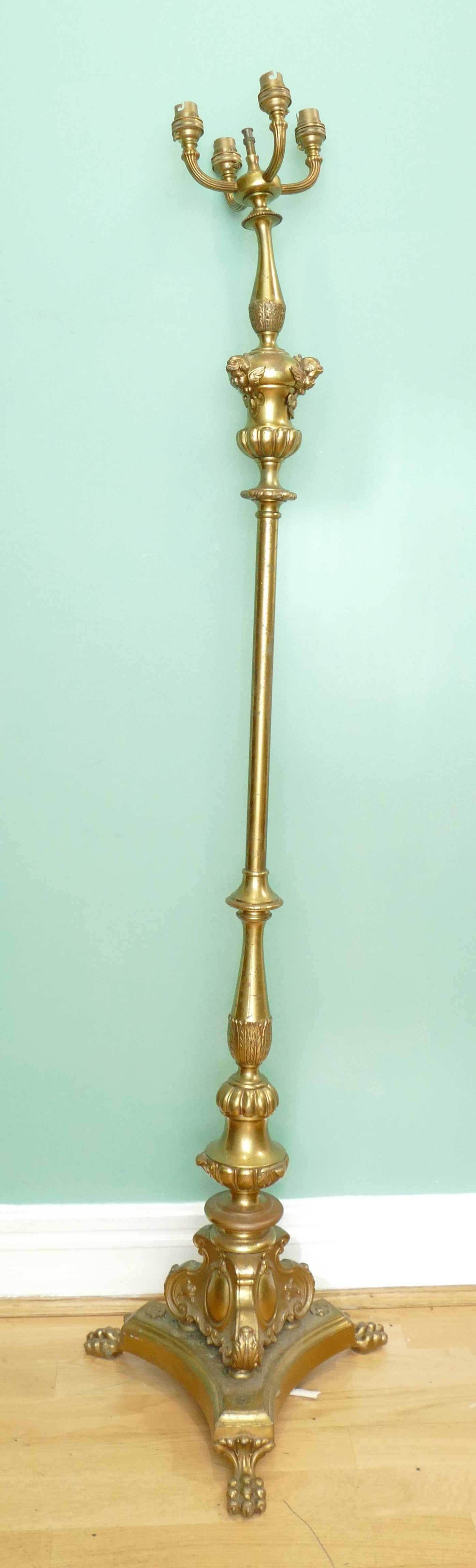 A Louis XV style gilt brass floor standing lamp, having four branch fittings, turned column with