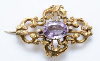 A Victorian unmarked gold and amethyst brooch, with chased foliate scroll frame, 60 x 40mm, 12gm.