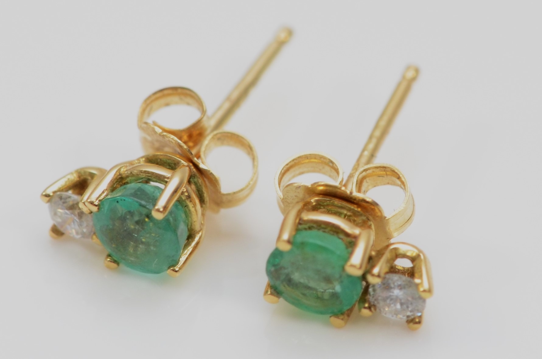 An 18ct gold pair of emerald and brilliant cut diamond pair of ear studs, 0.8gm - Image 2 of 2