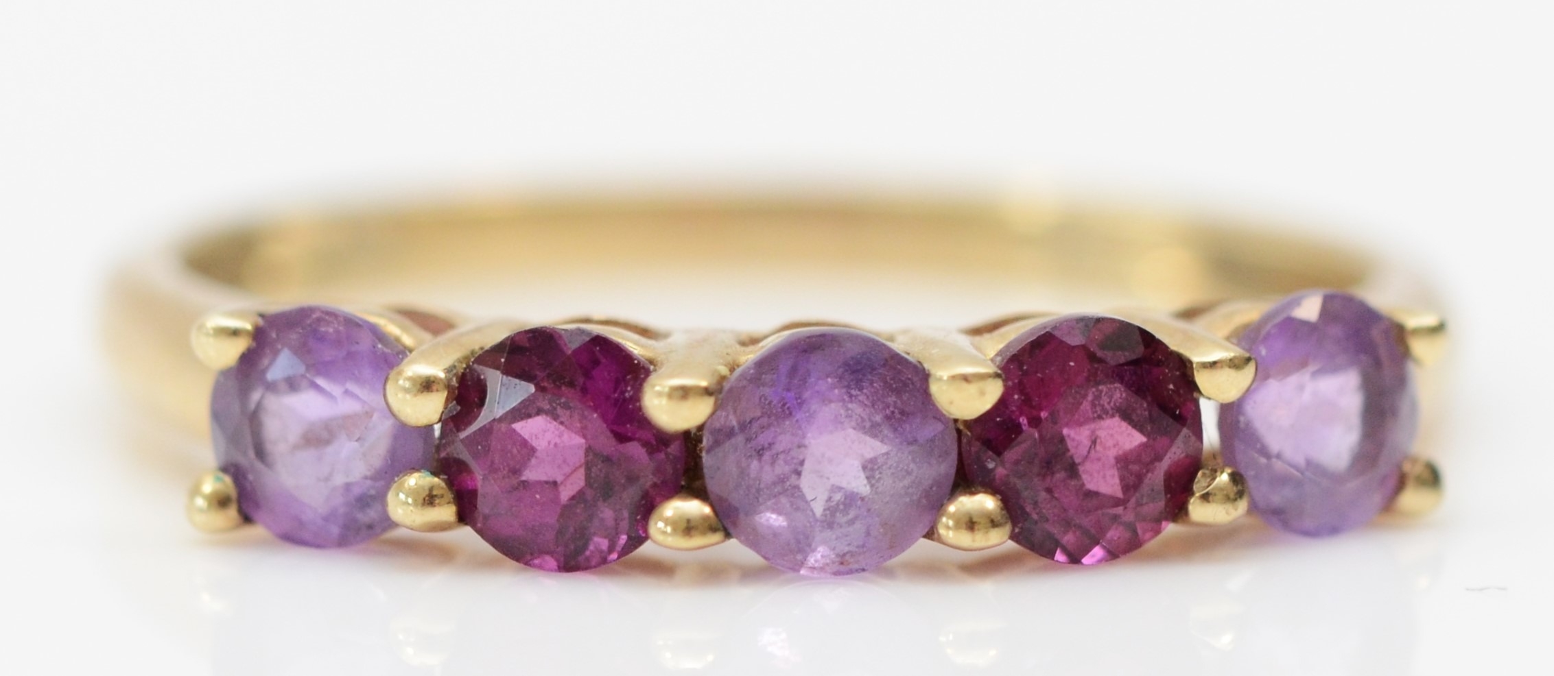 A 9ct gold amethyst and purple garnet five stone ring, O, 1.3gm