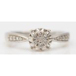 A 9ct white gold and brilliant cut diamond cluster ring, diamond set shoulders, stated weight 0.