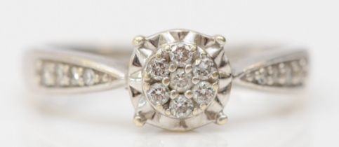 A 9ct white gold and brilliant cut diamond cluster ring, diamond set shoulders, stated weight 0.