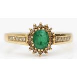 A 9ct gold emerald and diamond cluster ring, diamond set shoulders, S, 2.7gm