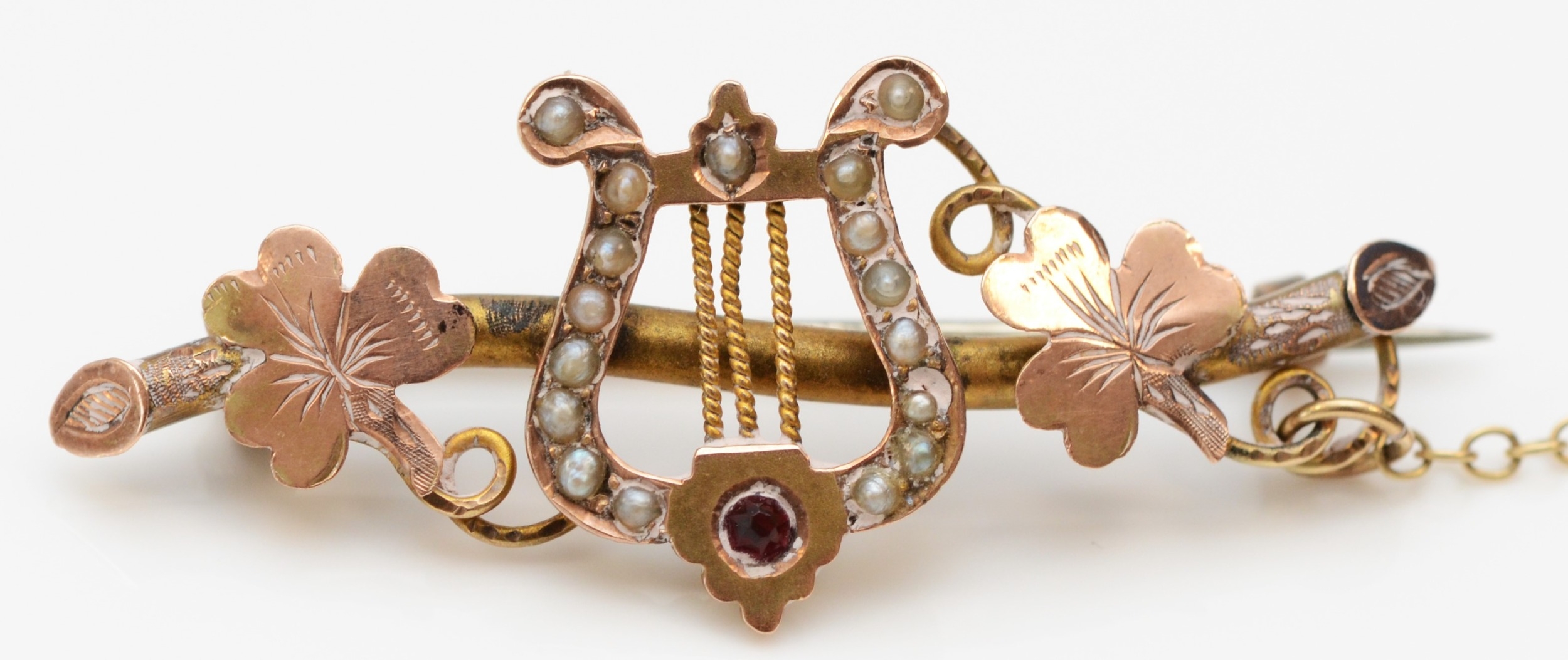 A Victorian 9ct rose gold red stone and half pearl harp and clover leaf brooch, Birmingham 1892,