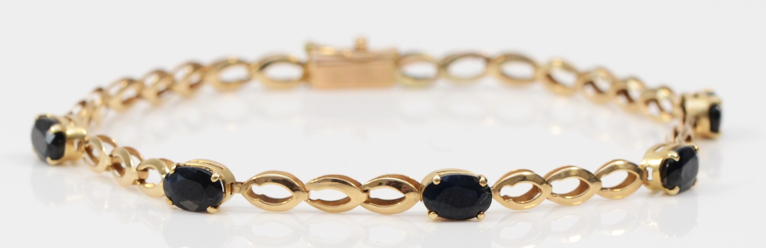 A 9ct gold and sapphire set line bracelet, 17.5cm, 2.9gm