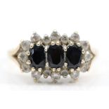 A 9ct gold three stone sapphire and white stone dress ring, T, 3.4gm.