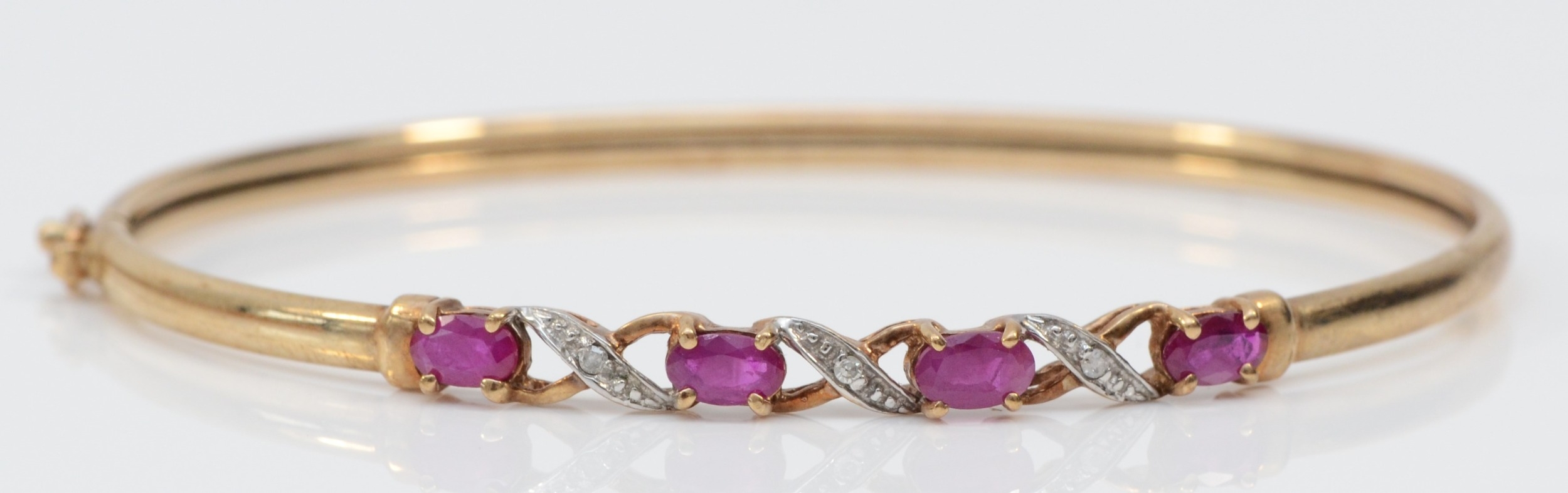 A 9ct gold ruby and diamond bangle, 60 x 50mm, 4.7gm