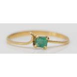 An unmarked gold and emerald single stone ring, tests 18ct, O, 1.3gm