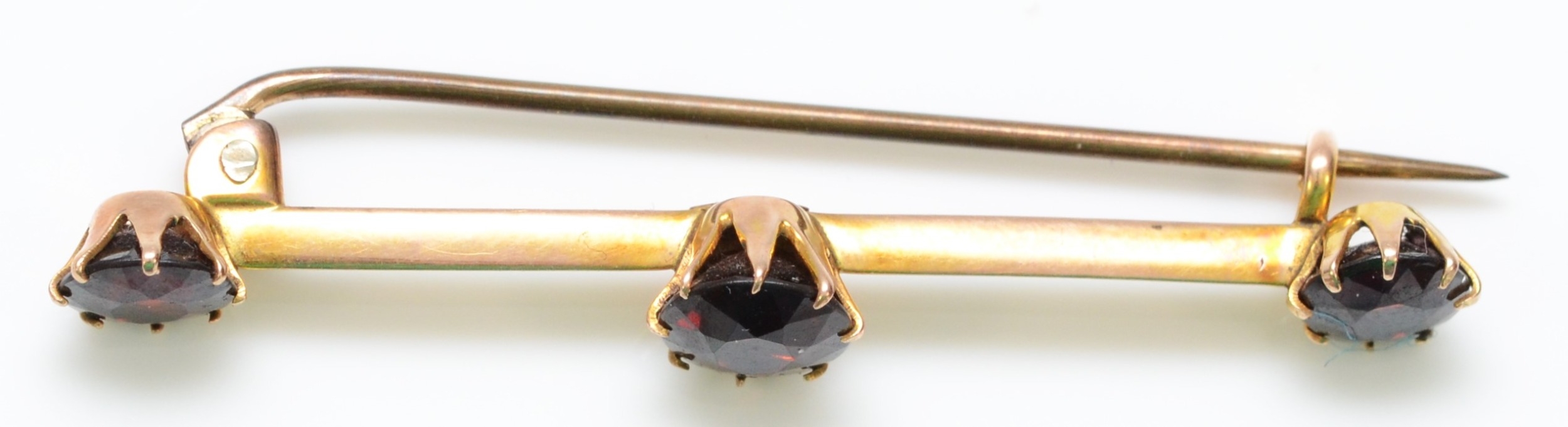 A 9ct gold bar brooch, set with three garnets, 19mm, 2.2gm, metal pin - Image 2 of 2