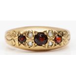 A Victorian style 9ct gold star gypsy set garnet and white stone ring, central garnet chipped, O,
