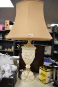 A 20th Century resin urn form table lamp decorated with a classical design, with shade, measuring