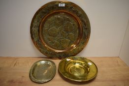 A 20th century Eastern copper charger, having pierced floral decoration, sold with a brass alms dish