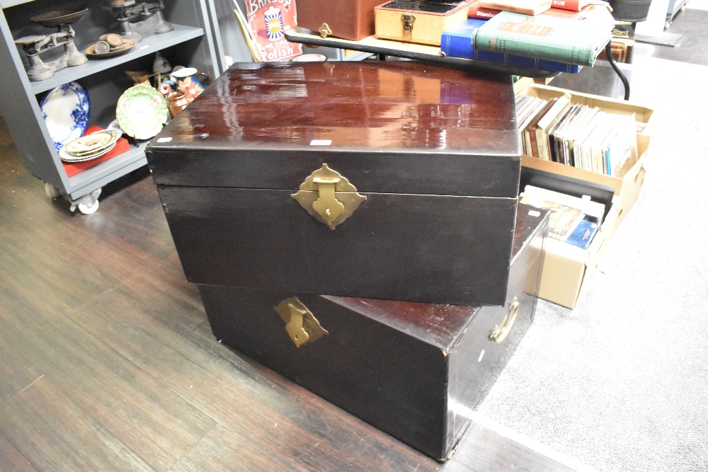 Two lacquered chests, containing a selection of oriental clothing.