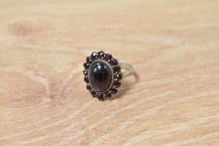 A garnet cluster ring on a white metal loop, no marks, size P & approx 4g
