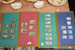 Four framed and glazed collections of stamps.
