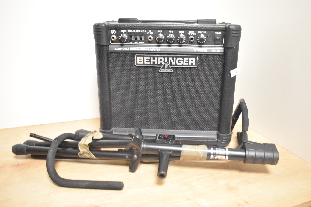 A Behringer portable amplifier and a guitar stand.