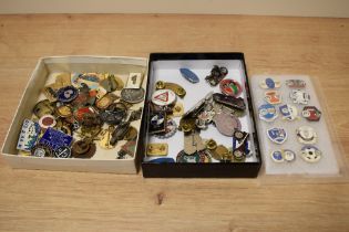 An assortment of badges, including vintage British Legion, Triumph, Honda, Matchless and Rudge