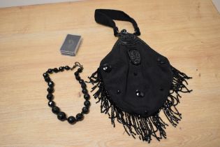 A late Victorian handbag, having moulded vulcanite handle and faceted beaded necklace.