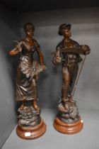 Two late 19th century cast metal bronzed effect figurines sat on wooden bases, depicting a male